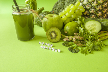 Green health smoothie fruits and vegetables, kale leaves, lime, apple, kiwi, grapes, banana, avocado, lettuce pineapple salat. Copy space. Raw, vegan, vegetarian, alkaline food concept.の写真素材