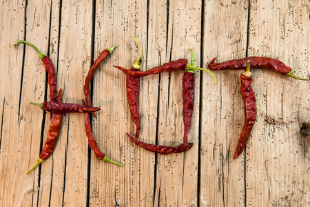Above Shot Of Hot Text Made With Red Chili Peppers On Wood Tableの写真素材
