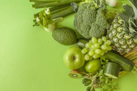 Green health smoothie fruits and vegetables, kale leaves, lime, apple, kiwi, grapes, banana, avocado, lettuce pineapple salat. Copy space. Raw, vegan, vegetarian, alkaline food concept.の写真素材