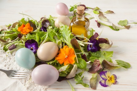 Lettuce and flower salad on woody white background spring, easter