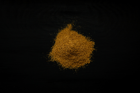 Close-up image of cumin powder on black wood background, view aboveの写真素材