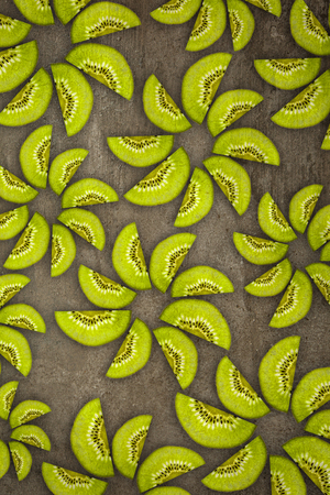 Creative flowers made of Kiwis cut from below lit on a stone background Food conceptの写真素材