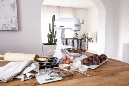 White kitchen machine and stand mixer on a wooden table in a bright design apartmentの写真素材