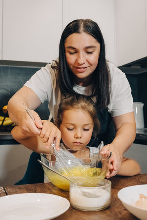 A Mother and Her Child Enjoy Cooking Together in Their Modern Family Kitchen Space. Happy family...