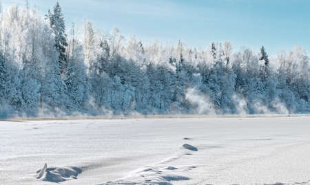 Dvina rver under ice  Not frozen sites of the river are in the distance noticeable  Over these sites steam rises  Landscape near Zdrawneva  The municipality of Ruba  Belarus  2013 の写真素材