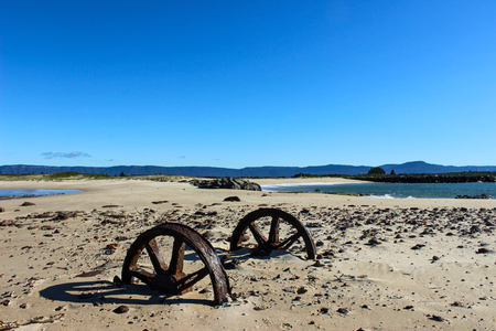 corroded and stranded wheels stuck in sandの写真素材
