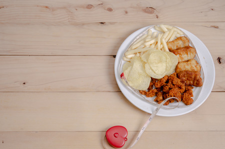 Crisps Fried food in white plate The waistline is on the table.Healthy eating and active lifestyle concept.Do not focus on objects.の写真素材