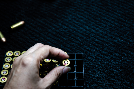 Bullet in hand on black background.Woman hand catches ammunition.の写真素材