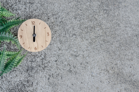 The clock with green leaves on the floorの写真素材