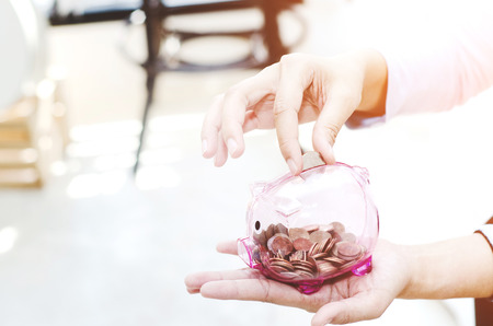 Coin in the pink piggy bank.saving moneyの写真素材