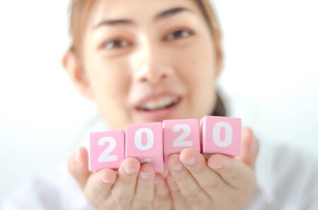 The box with the numbers in 2020, placed on a white futon and the woman's hand picked up the box