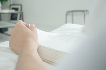 Index finger on the book On a white mattress in the bedroom.Do not focus on the main object of this...