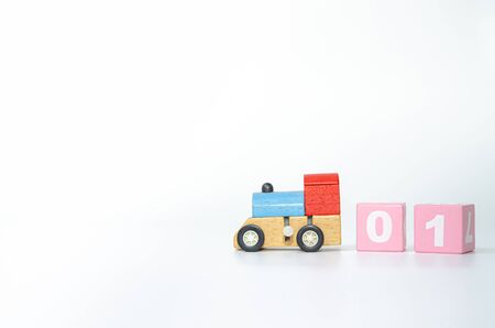 Wooden toy train head rests on a white background.Pink and gray colored wooden boxes 01, isolated from the white floor.copy space.の写真素材