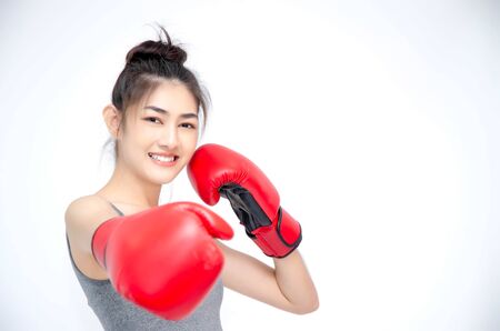 Asian Woman Wearing Red Boxing Gloves.The girl put her hands on her ears.Women are tired.の写真素材