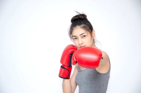 Asian Woman Wearing Red Boxing Gloves.The girl put her hands on her ears.Women are tired.の写真素材