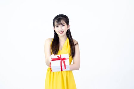 Beautiful asian woman The yellow dress is smiling Hold a gift box.Do not focus on objects.solated on white background.Copy space.の写真素材