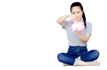 Pink pig coin jar in Asian woman's hand, gray shirt.Isolated on white background.Copy space.の写真素材