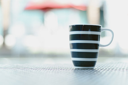 Blue coffee cup Put on a table by the pool in the morning.の写真素材