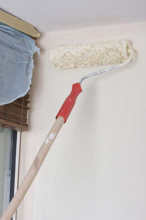 house painter using a paint roller, painting a wall in motion 
