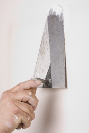 Putty Knife with Paste to Repair Wall Damageの写真素材