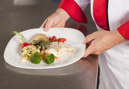 chef in kitchen presenting dish の写真素材