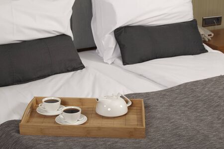 Tray with coffee on a bed in a hotel room 