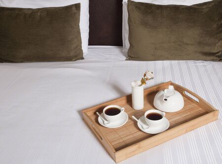 Tray with coffee on a bed in a hotel room 