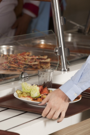 buffet self-service food display human hand take plate の写真素材
