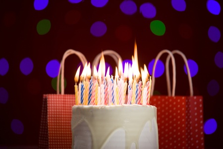 happy birthday cake shot on a red blurred background with candles