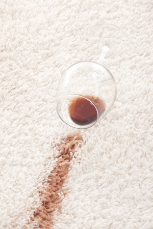 A glass of spilled coffee  on brand new carpet is sure to leave a stain.の写真素材