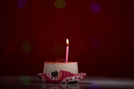 happy birthday cake shot on a red blurred background with candlesの写真素材
