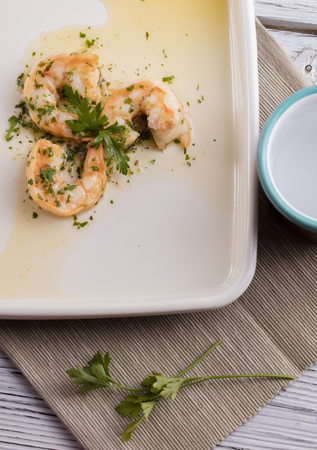 shrimps on white plate on wooden backgroundの写真素材