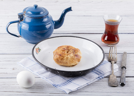 turkish borek boyoz with egg and tea on wooden backgroundの写真素材