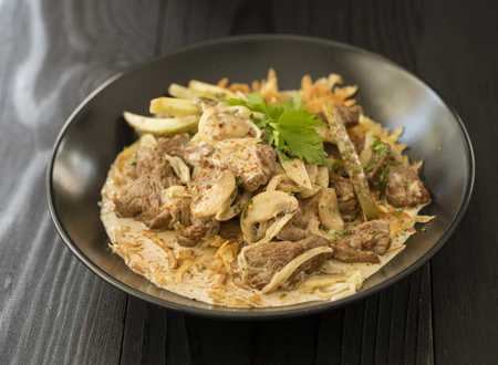 beef stroganoff  in black plate of beef ,mushroom and onion in cream sauceの写真素材