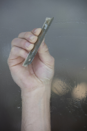 A soapy window with a squeegee cleaning the glassの写真素材