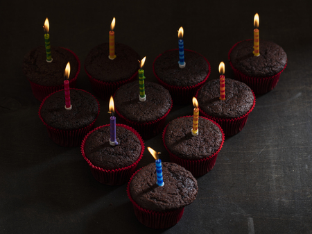 chocolate birthday cupcake with candle over dark backgroundの写真素材