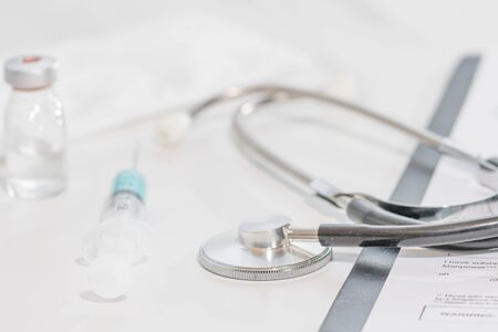 White background doctor office with stethoscope and blue injection