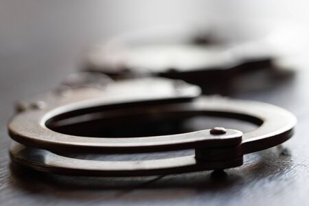 Handcuffs on brown background
