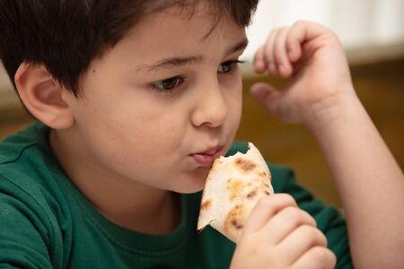 Traditional delicious Turkish food; Turkish lahmacun.The boy is eating it.の写真素材