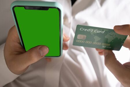using cell phone holding a credit card and for online shopping. commerce concept and online buy