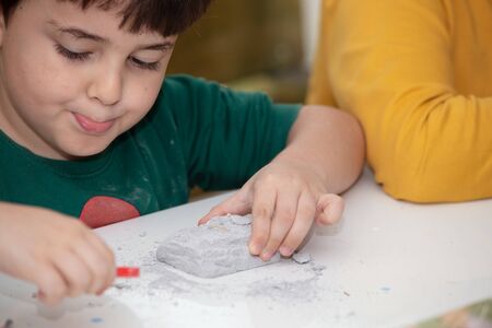 children's entertainment, a child plays in an archaeologist, children's hands dig dinosaur bonesの写真素材