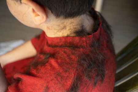 Father cutting hair of son at home during 2020 Covid-19 pandemic crisis