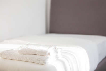 White clean towels stacked on the hotel bed. High quality photoの写真素材