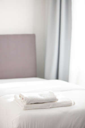 White clean towels stacked on the hotel bed. High quality photo