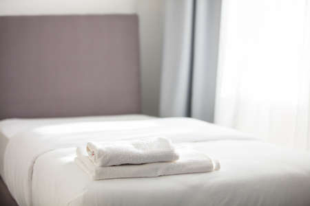 White clean towels stacked on the hotel bed. High quality photoの写真素材