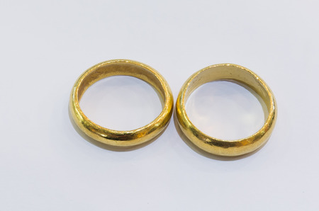 Two gold  rings on a white background.の写真素材