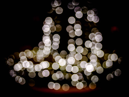 Abstract blur bokeh blurred background of decorated glowing Christmas tree and fireplace.の写真素材