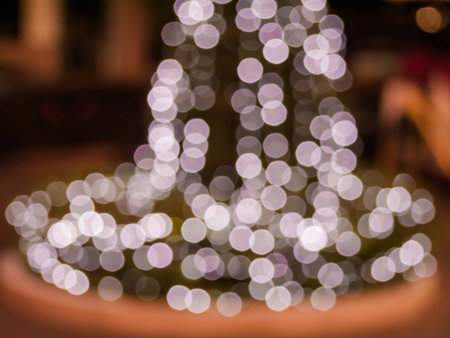 Abstract blur bokeh blurred background of decorated glowing Christmas tree and fireplace.の写真素材