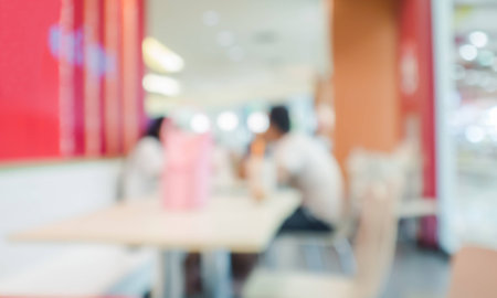abstract blurred couple eating fast food in fast food shop in shopping mall.の写真素材