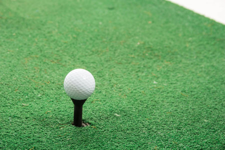 White golf ball on green grass isolated on white with shadow horizontal background with selective focus.の写真素材